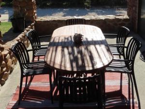 a wooden table with four chairs around it at Klipspringer Cottage in Prince Alfreds Hamlet +3 photos
