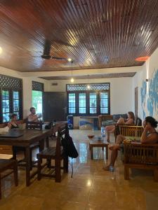 a group of people sitting at tables in a room at Ryo hostel in Ahangama
