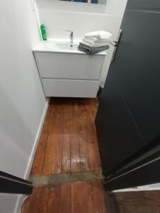 a bathroom with a sink and a wooden floor at Charmant studio cosy - Hyper centre in Saint-Gaudens