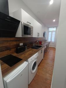 a kitchen with a sink and a washing machine at Charmant studio cosy - Hyper centre in Saint-Gaudens
