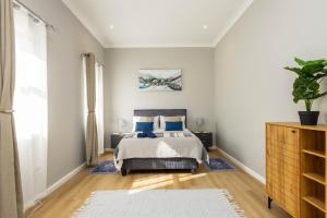 a bedroom with a bed with blue pillows at Nova Haus in Plettenberg Bay +18 photos