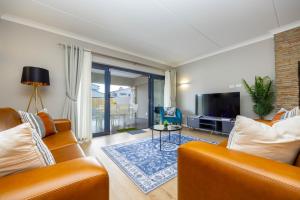 a living room with a couch and a tv at Nova Haus in Plettenberg Bay
