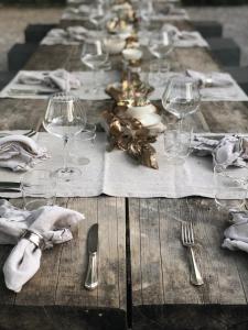 a long wooden table with wine glasses and napkins at La Saracina in Pienza +127 photos
