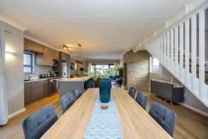 a kitchen and dining room with a long table and chairs at Nova Haus in Plettenberg Bay