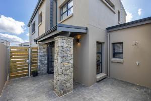 a house with a stone pillar next to a building at Nova Haus in Plettenberg Bay