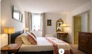 a bedroom with a bed and a table and a window at La petite hostellerie in Uzès