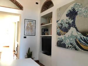a room with a tv and a painting on the wall at Isola Blu Milano in Milan