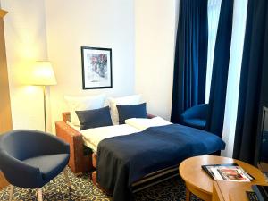 a hotel room with a bed and a chair at Hotel am Kurpark in Schönebeck +24 photos
