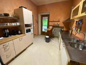 a kitchen with a sink and a refrigerator at Le Colombier d'Antan in Les Vans