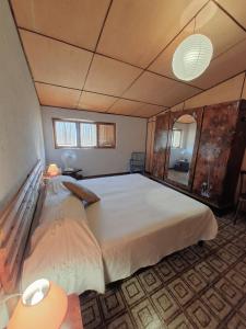 a bedroom with a large bed and a mirror at White Cottage - WelcHome in Mozzagrogna