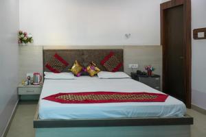 a bedroom with a large bed with red and gold pillows at Hotel satkar in Parāsia
