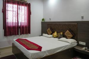 a bedroom with a large bed with red curtains at Hotel satkar in Parāsia