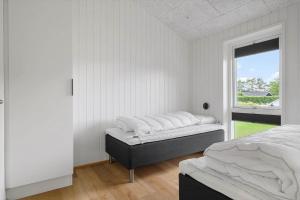 a white bedroom with two beds and a window at OH513-Hadsund-Haslevgarde-Eng-14 in Hadsund