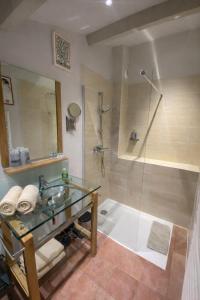 a bathroom with a glass sink and a shower at La petite hostellerie in Uzès