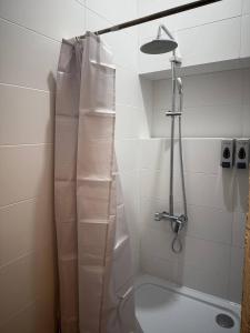 a shower with a shower curtain in a bathroom at Fresh hostel in Almaty