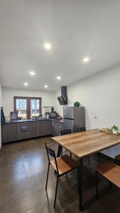 a large kitchen with a wooden table and chairs at Lauviņu rezidence in Kocēni