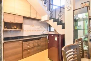 a kitchen with wooden cabinets and a staircase at Klassone Bunglow in Khandāla
