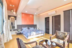 a bedroom with a bed and a table and chairs at Klassone Bunglow in Khandāla