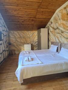 a bedroom with a large bed in a stone wall at Hirmas boutique hotel in Tbilisi City