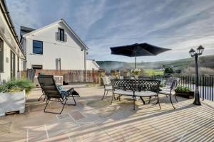 a patio with a table and chairs and an umbrella at 1 Bed in Croyde oc-forda in Croyde