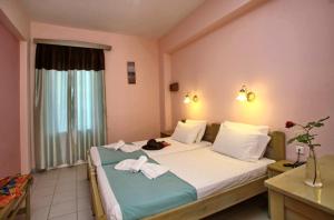 a hotel room with two beds with towels on them at Dolphin Hotel in Skopelos Town