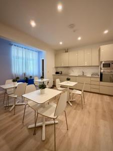 a room with tables and chairs and a kitchen at Apartment 81 in Mosta