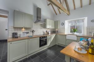 a kitchen with white cabinets and a wooden table at 1 Bed in Lowick oc-coq44 in Holburn