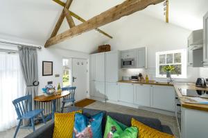 a kitchen and living room with white cabinets at 1 Bed in Lowick oc-coq46 in Holburn