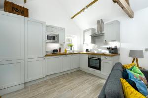 a white kitchen with white cabinets and a couch at 1 Bed in Lowick oc-coq46 in Holburn +19 photos