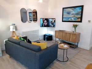 a living room with a blue couch and a table at 1 Bed in Lowick oc-coq46 in Holburn