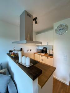 a kitchen with a counter with a clock on the wall at Chalet-Apartment Waldfrieden, in ruhiger Lage mit TG in Hahnenklee-Bockswiese