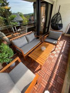 a patio with two couches and a table at Chalet-Apartment Waldfrieden, in ruhiger Lage mit TG in Hahnenklee-Bockswiese