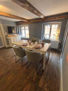a dining room with a white table and chairs at Millers Kate mit Elbblick in Lauenburg