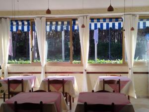 a room with tables and chairs in front of windows at Albergo Tre Stelle in Marina di Grosseto