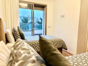 a bedroom with two beds with pillows and a window at Beachside Holiday Apartment in Mohammedia
