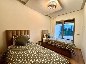 a bedroom with two beds and a window at Beachside Holiday Apartment in Mohammedia