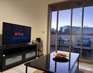 a living room with a television and a bowl of fruit on a table at Beachside Holiday Apartment in Mohammedia +15 photos