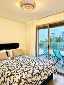 a bedroom with a bed and a balcony at Beachside Holiday Apartment in Mohammedia