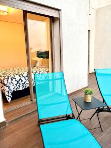 two blue chairs and a table on a balcony at Beachside Holiday Apartment in Mohammedia