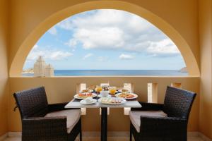 a table with a view of the ocean from a window at Archipelagos Apartments in Arkasa