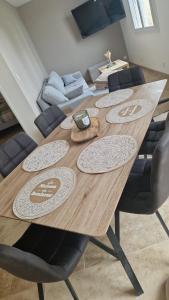 a wooden dining room table with chairs and a couch at Maison pour 6 personnes in Le Bugue