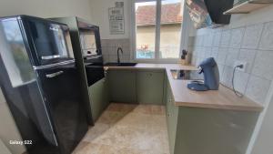 a kitchen with a black refrigerator and a counter at Maison pour 6 personnes in Le Bugue