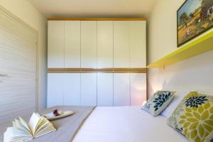 a bedroom with a bed with a book on it at L15 Appartamento Asinara in Stintino +22 photos