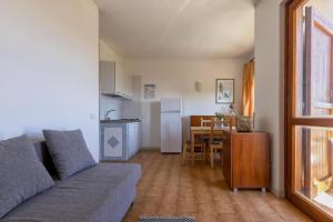 a living room with a couch and a kitchen with a table at L15 Appartamento Asinara in Stintino