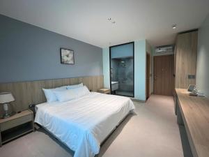 a bedroom with a large white bed and a walk in shower at Balat Resort in Tập Thiện +35 photos