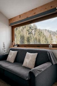 a couch in a room with a window with a star on it at Loft Malga Laghetto in Lavarone