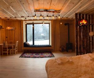 a room with a bed and a window and a table at Будиночок між річками Гирло in Iltsi