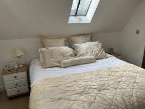 a bedroom with a white bed with pillows and a window at Charming Detached Cottage Guest Room in Silsoe Village in Bedford