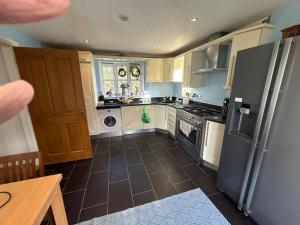 a kitchen with a refrigerator and a dishwasher at Charming Detached Cottage Guest Room in Silsoe Village in Bedford