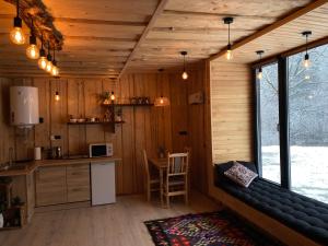a kitchen with a couch in a wooden cabin at Будиночок між річками Гирло in Iltsi +12 photos
